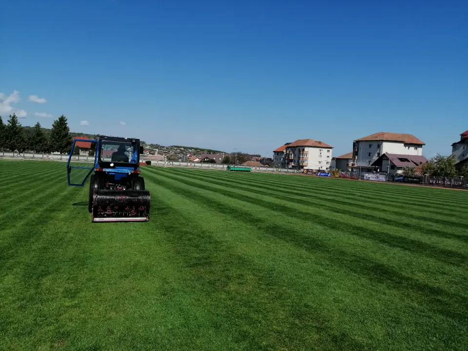Tractor cu Verti-Drain aerând gazonul unui teren de fotbal